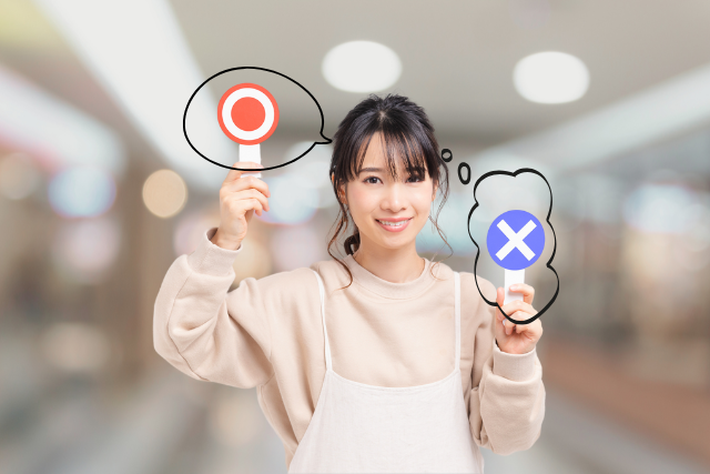 A person holding a magnifying glass over a red target and a blue cross, symbolizing precision and accuracy in decision-making.